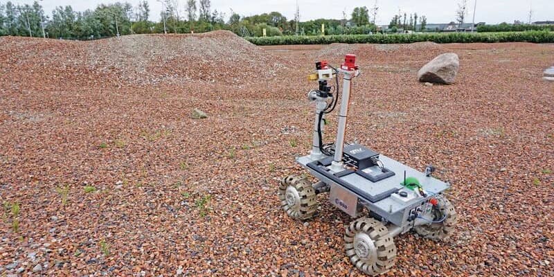 An ESA team member operates the rover on one of the team's tests sites.