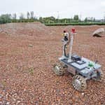 An ESA team member operates the rover on one of the team's tests sites.