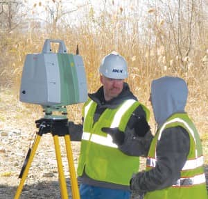 The author and one of his party chiefs scan the underside of a bridge for a bridge improvement project. 