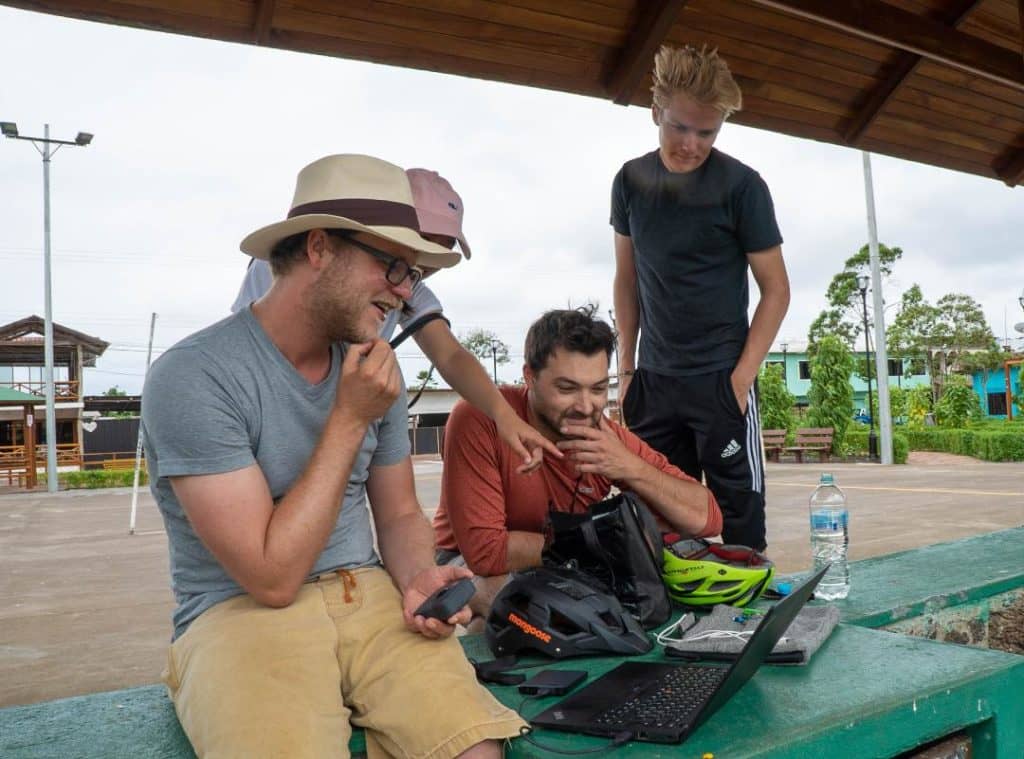 Daniel Zünd and Chris Beddow (seated, left to right) in Puerto Baquerizo Moreno, checking the images collected using a 360° camera that was mounted on top of a bike helmet. © Amy Tian