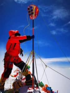 Raising the survey rod on the “roof of the world.” The P5 GNSS receiver (front-center) collected around 150 minutes  of GNSS observations, the longest GNSS session on Everest to date.