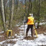 Kirk Norton, NPS land surveyor for the AT, sets up a foresight in Pennsylvania with help from members of the Potomac Appalachian Trail club on the hill above him. Credit: Nicole Wooten.