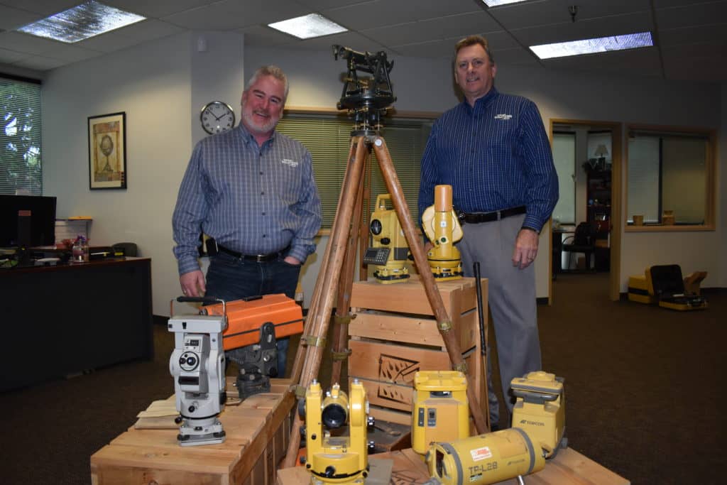 Mark Contino, vice president of North American retail distribution at Topcon Positioning Systems (left) and Ken Shersty, director of hardware sales for TSS, in a small museum of survey gear in The Solutions Store Kent, Washington, location.