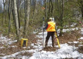 Kirk Norton, NPS land surveyor for the AT, sets up a foresight in Pennsylvania with help from members of the Potomac Appalachian Trail club on the hill above him. Credit: Nicole Wooten.