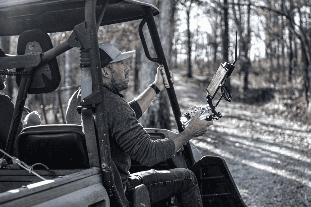 Matt Rosenbalm (left) and Jeff Davis (right) follow their surveying drone in an ATV to keep the mdLiDAR-1000 within visual line of sight.